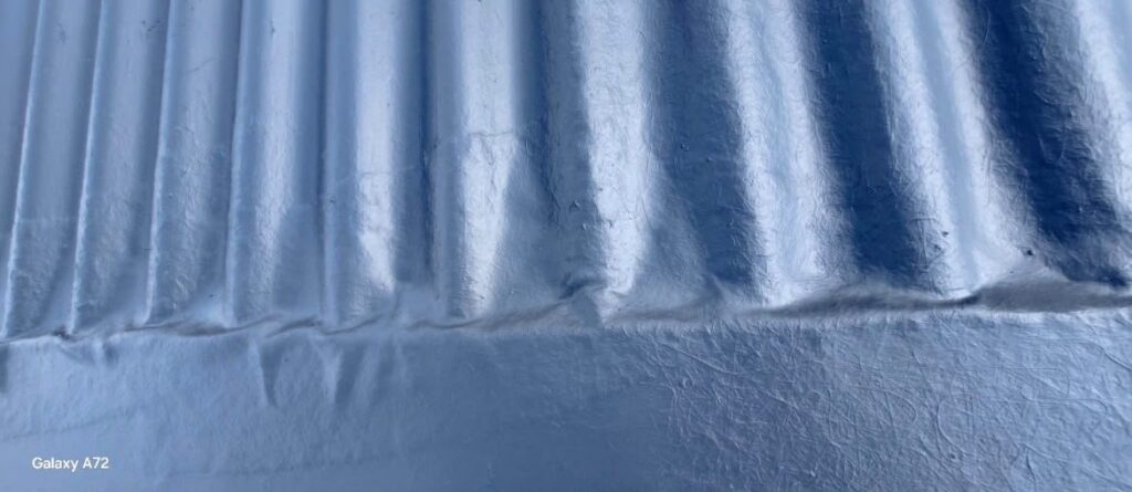 Coated corrugated sheet overlap and joint, close-up