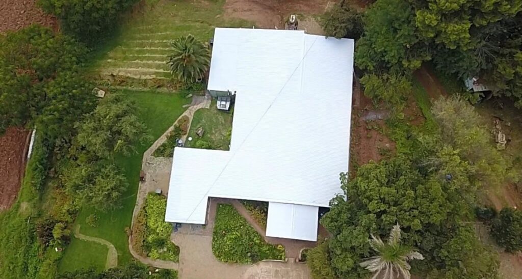 The same house roof after restoration with a white protective coating