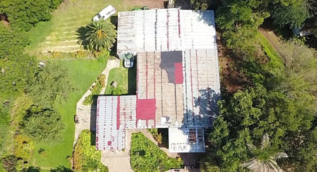 Rusted metal roof on a house before restoration, seen from above