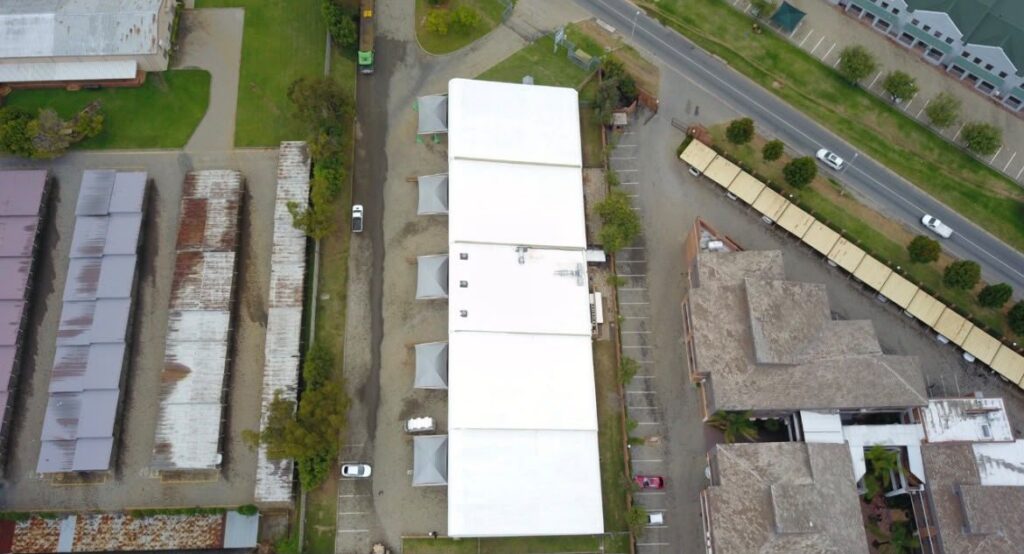 Aerial view of a long commercial roof with a white protective coating