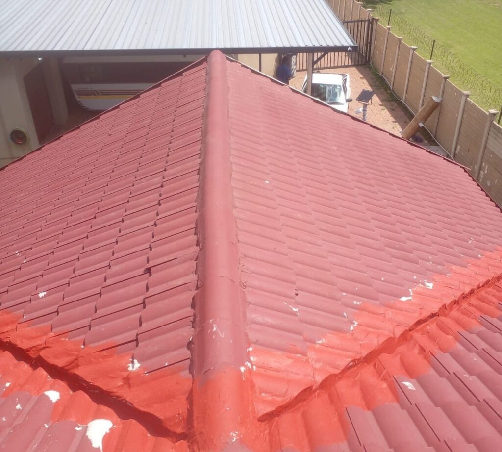 Red coated roof tiles and ridge, close-up
